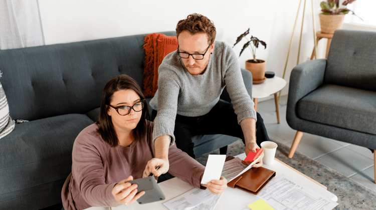 Image of a man and woman looking at a calculator.