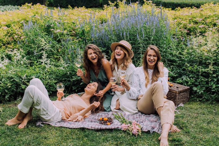 Image of four women having a picnic in a garden