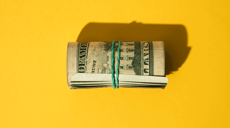 Image of a roll of twenty-dollar bills on a yellow background.