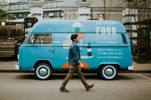 Image of a man walking in front of a food truck