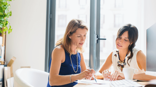 Image of two women working together in an office.